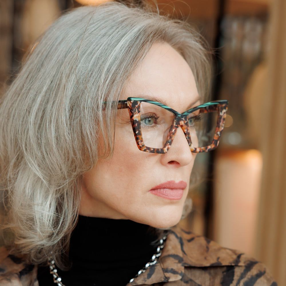 Silver-haired woman wearing a tortoiseshell Arthur frame