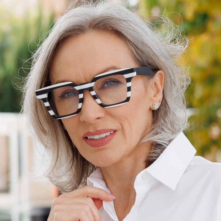 Woman in a white shirt wearing a black-and-white Lawrence frame