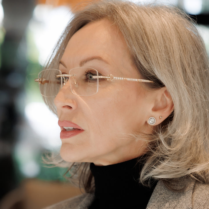 Silver-haired woman wearing a gold-tone rimless Warrick frame
